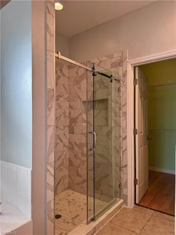 Bathroom with hardwood / wood-style flooring and an enclosed shower
