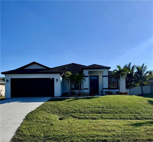 View of front of home featuring a front yard and a garage