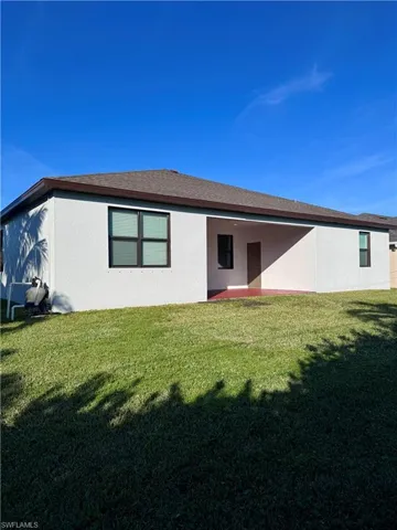Back of house featuring a yard