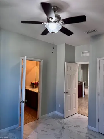 Bedroom featuring connected bathroom and ceiling fan
