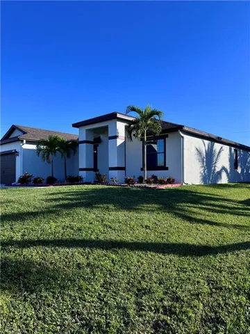 View of front of home featuring a garage and a front lawn