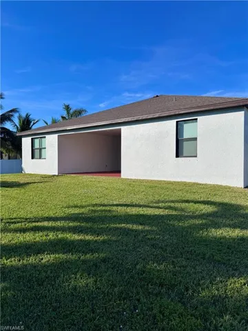 Back of property with a lawn