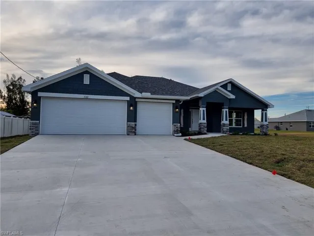 View of front facade with a garage and a front lawn