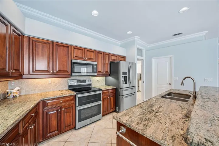 Kitchen with visible vents, a sink, stainless steel appliances, crown molding, and tasteful backsplash