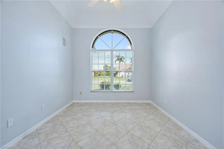 Unfurnished room featuring tile patterned flooring, visible vents, baseboards, and ceiling fan