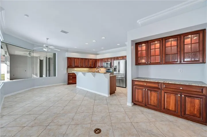 Kitchen featuring visible vents, ceiling fan, appliances with stainless steel finishes, crown molding, and a kitchen breakfast bar