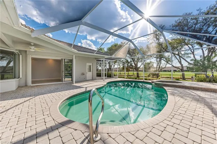 View of pool with a lanai, ceiling fan, a pool with connected hot tub, and a patio
