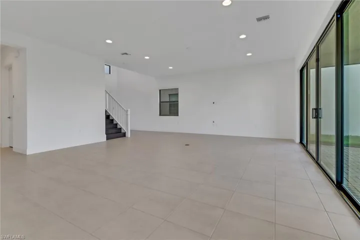 Empty room with stairway, visible vents, and recessed lighting