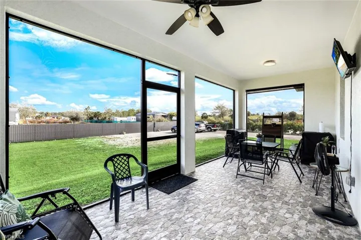 Sunroom featuring a ceiling fan and outdoor dining space