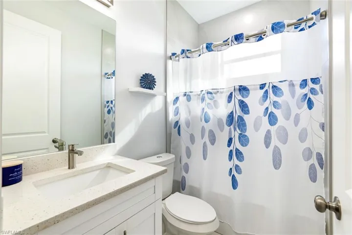 Bathroom with vanity and shower / bath combo with shower curtain