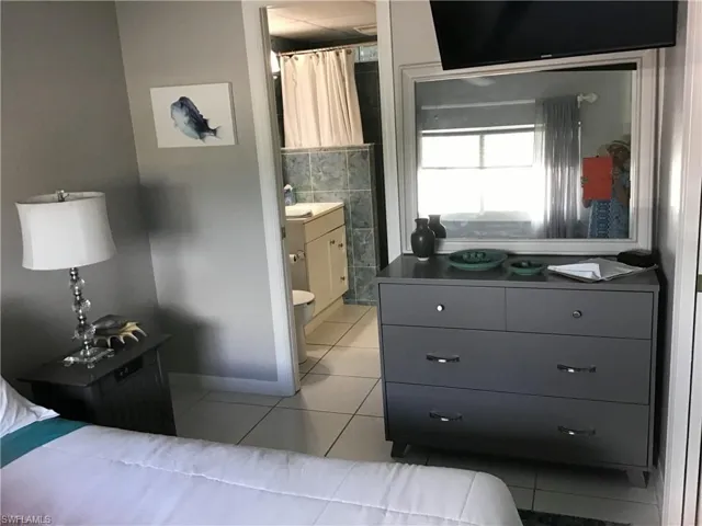 Bedroom with light tile patterned floor, ensuite bath