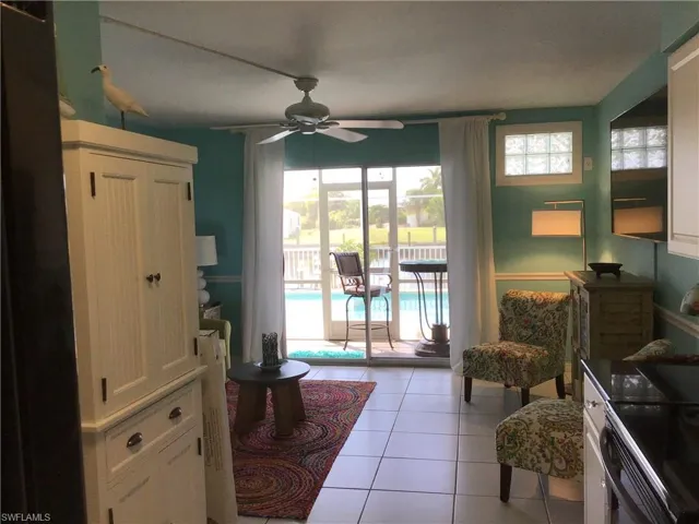 Living area featuring light tile patterned floors and ceiling fan