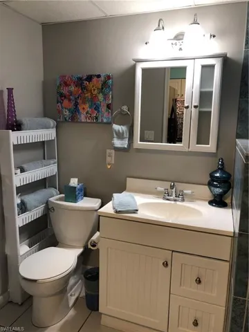 Bathroom with toilet, vanity, and tile patterned flooring