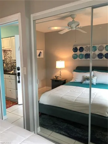 Bedroom featuring light tile and mirrored closet.