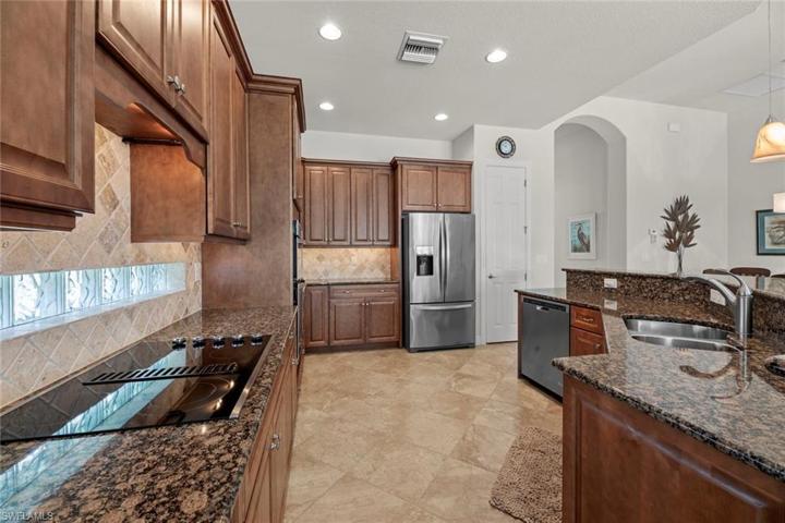 Granite counters, tile backsplash, and glass block window for extra light