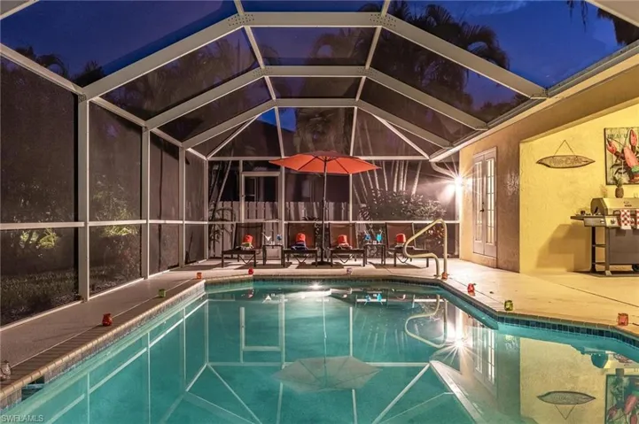 Outdoor pool featuring a patio area, grilling area, and a lanai