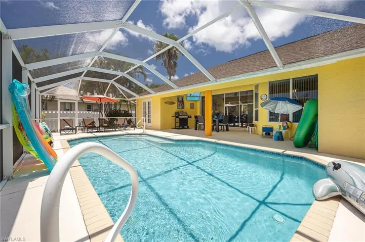 Outdoor pool featuring a patio, grilling area, and glass enclosure