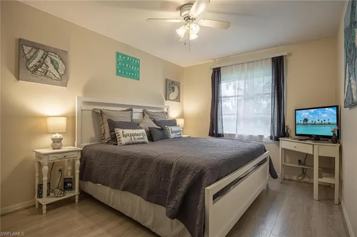 Bedroom with wood finished floors, baseboards, and ceiling fan