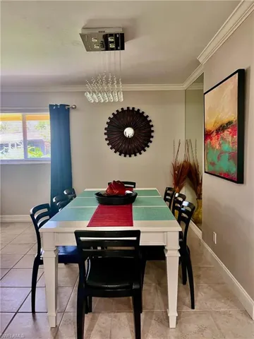 Dining area featuring ornamental molding and light tile flooring