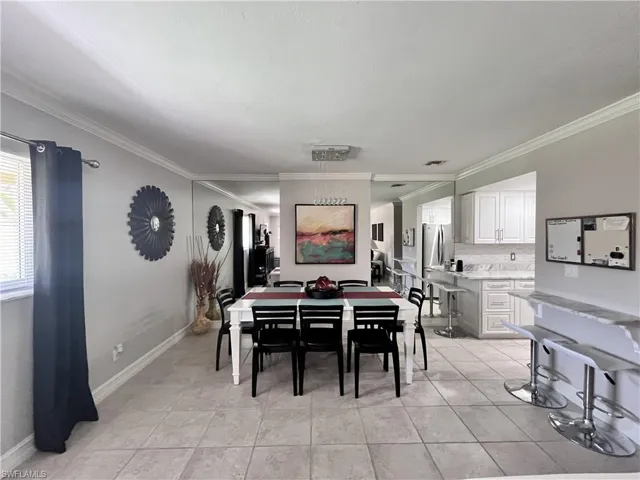 Dining room featuring ornamental molding and light tile floors