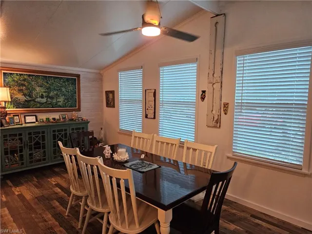 Dining space with lofted ceiling, crown molding, dark hardwood / wood-style floors, and ceiling fan
