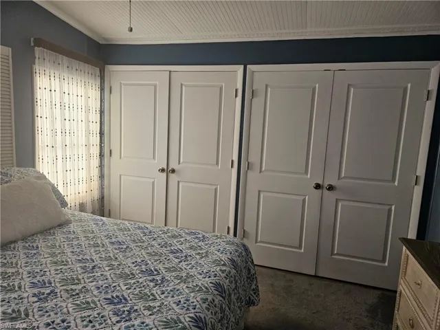 Bedroom featuring two closets and dark colored carpet