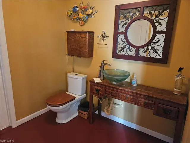 Half bathroom with a sink, baseboards, and toilet