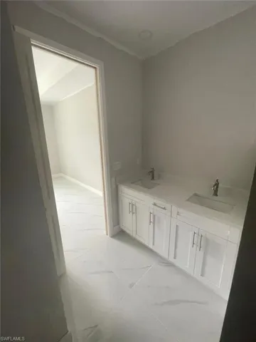 Bathroom featuring tile floors and dual sinks