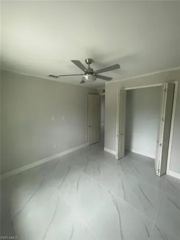 Unfurnished bedroom featuring ceiling fan and light tile flooring