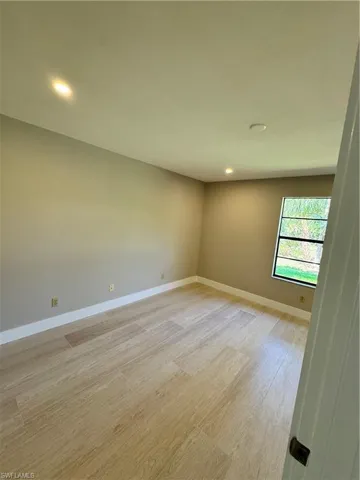 Empty room with light hardwood / wood-style flooring