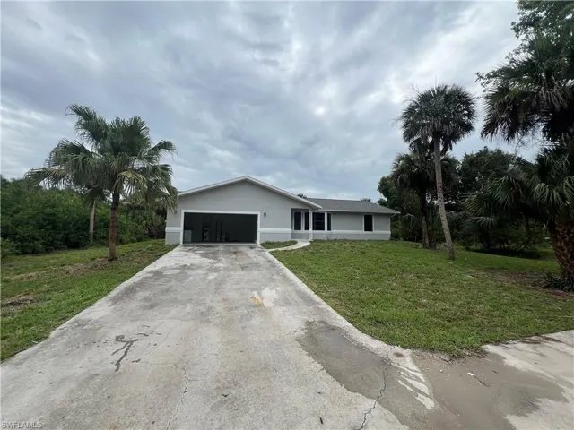 Ranch-style house with a garage and a front yard