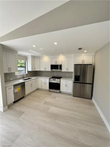 Kitchen with stainless steel electric range, dishwasher, tasteful backsplash, refrigerator, and sink