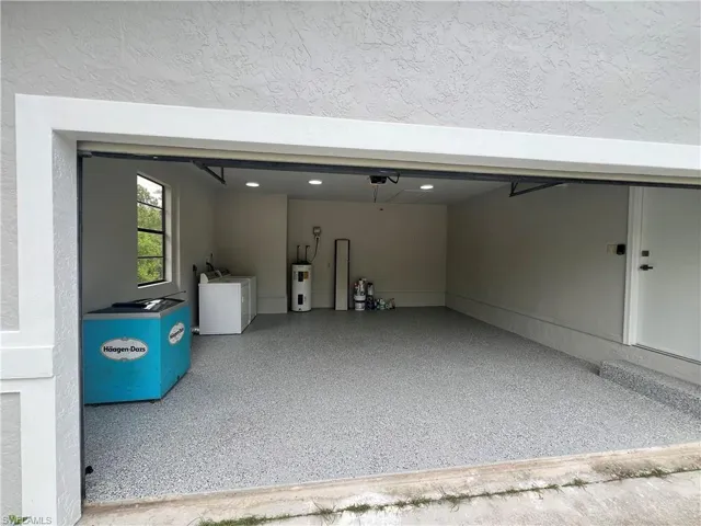 Garage featuring washer and dryer and electric water heater