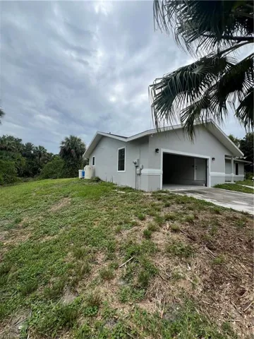 View of side of home with a garage and a yard