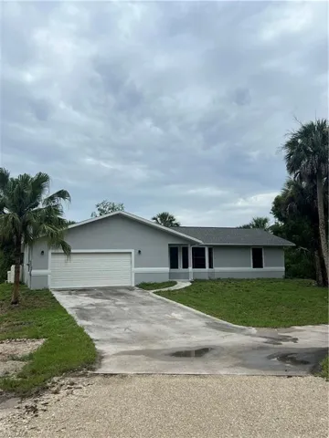 Ranch-style house with a front yard and a garage