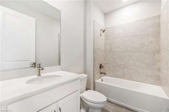 Bathroom with bathtub / shower combination, vanity, and wood finish floors