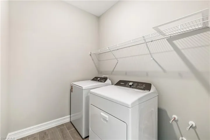 Washroom with wood tiled floors and washer and dryer