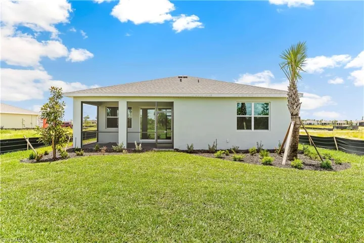 Back of property featuring roof with shingles, stucco siding, and a sunroom