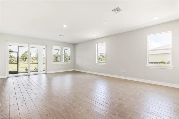 Unfurnished room with recessed lighting, wood finish floors, and healthy amount of natural light
