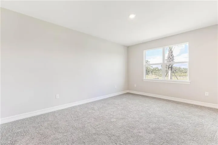 Carpeted empty room featuring baseboards and recessed lighting