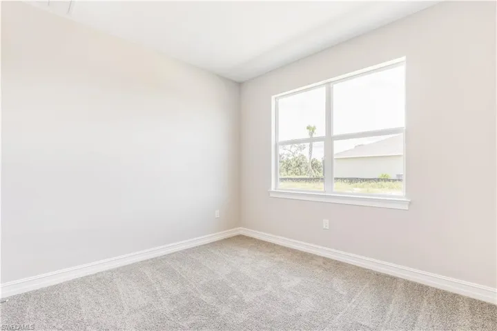 Carpeted empty room featuring baseboards