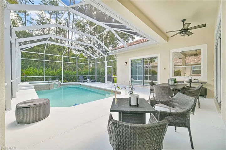 Combined pool / hot tub with a patio, a sunroom, outdoor dining area, and a lanai