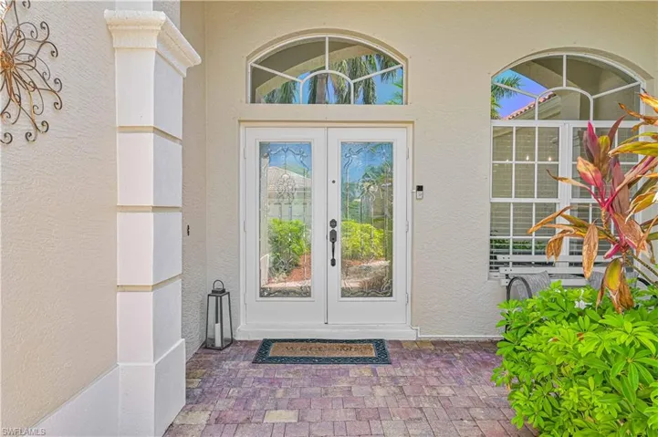 Doorway to property featuring french doors and stucco siding