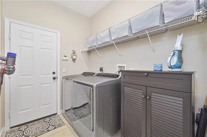 Laundry area featuring light tile patterned flooring and separate washer and dryer