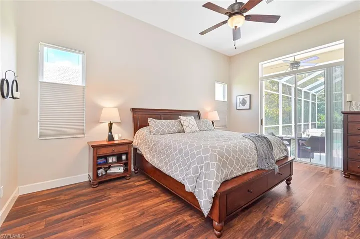Bedroom with dark wood-style floors, a ceiling fan, and access to exterior