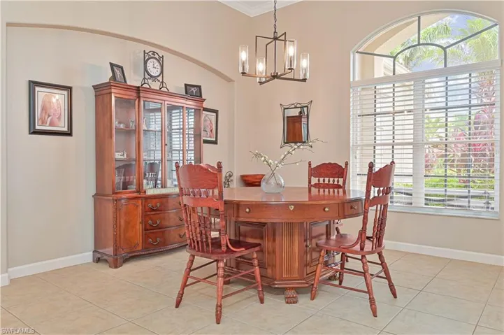 Dining area with a chandelier, crown molding, and light tile patterned floors