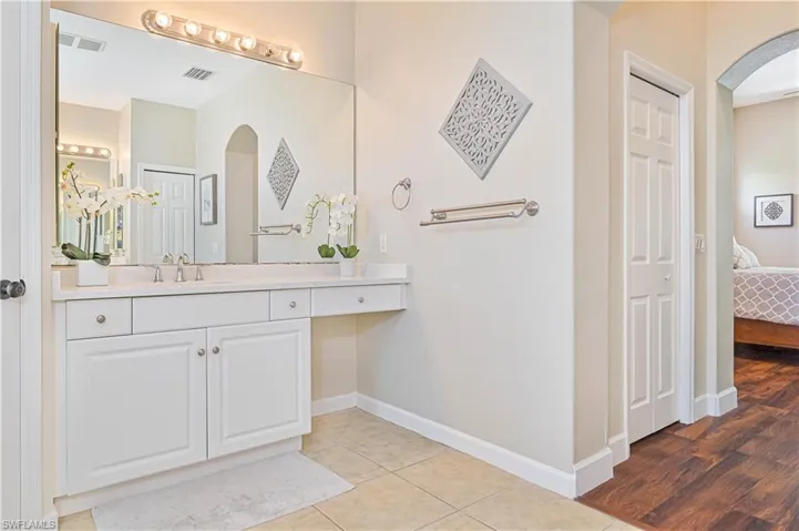 Bathroom featuring ensuite bath, vanity, and light tile patterned floors