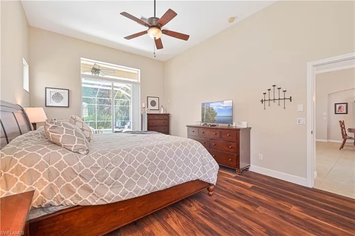 Bedroom featuring dark wood-type flooring, access to exterior, and ceiling fan