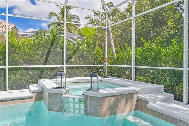 View of swimming pool with a sunroom, a lanai, and a jacuzzi