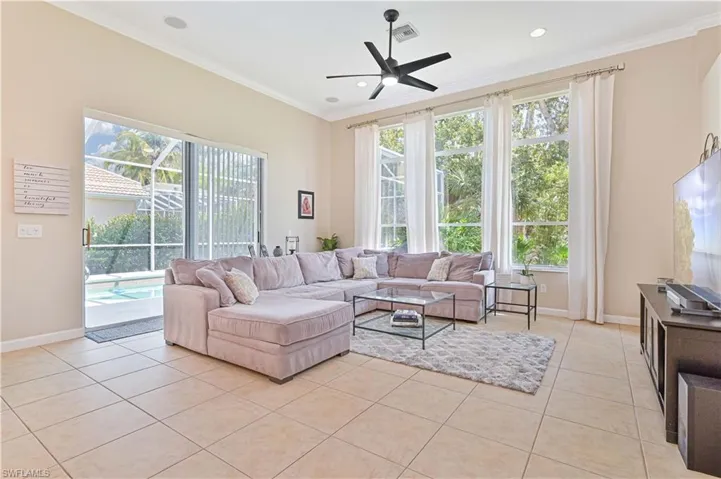Living room featuring ceiling fan, light tile patterned floors, ornamental molding, plenty of natural light, and recessed lighting